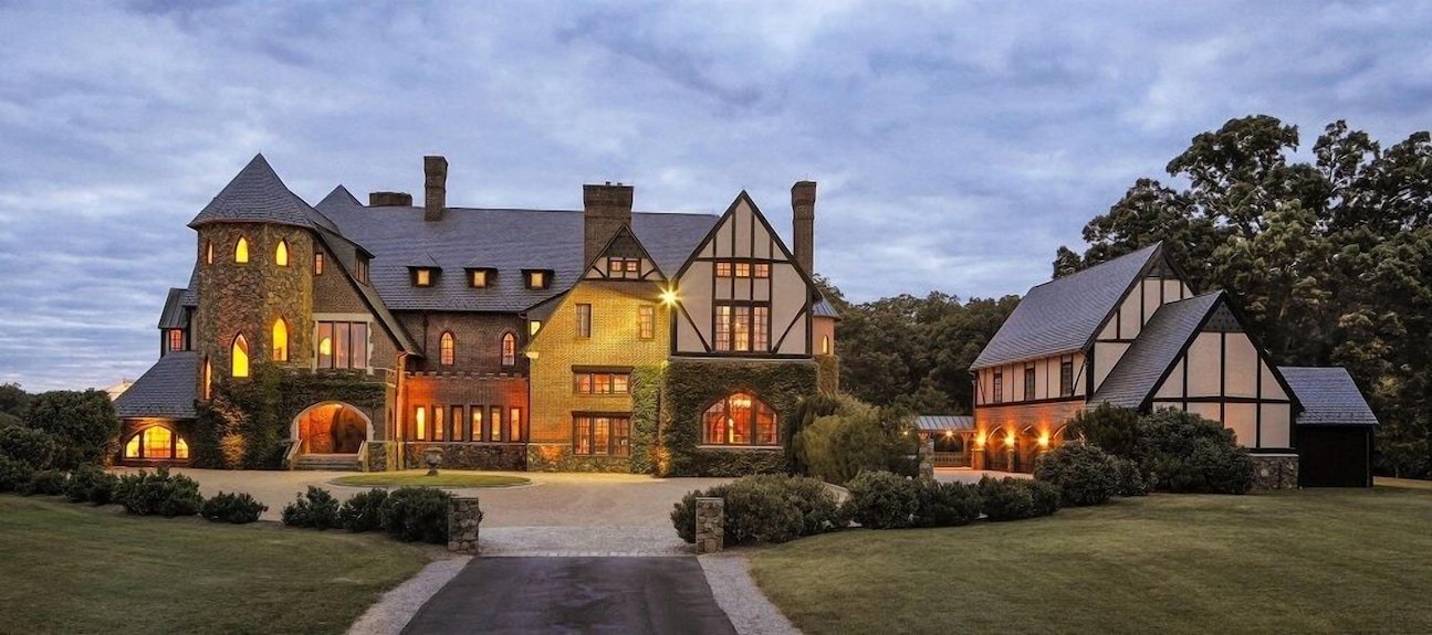 Dover Hall at dusk, every window lit, seen from the end of the front drive