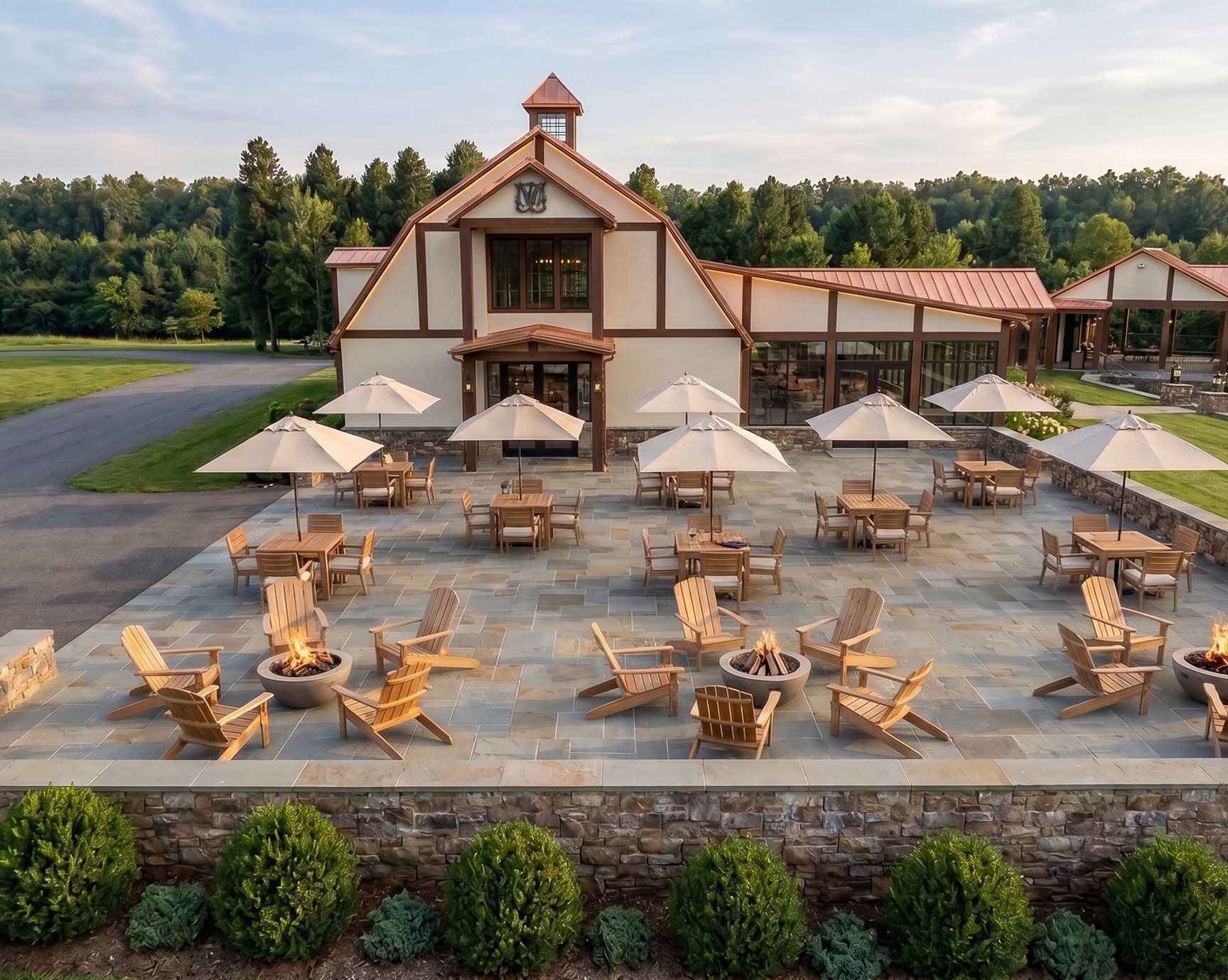 Aerial view of the 7 Lady Vineyards tasting room, its copper roofs and stone patio with fire pits and umbrellas