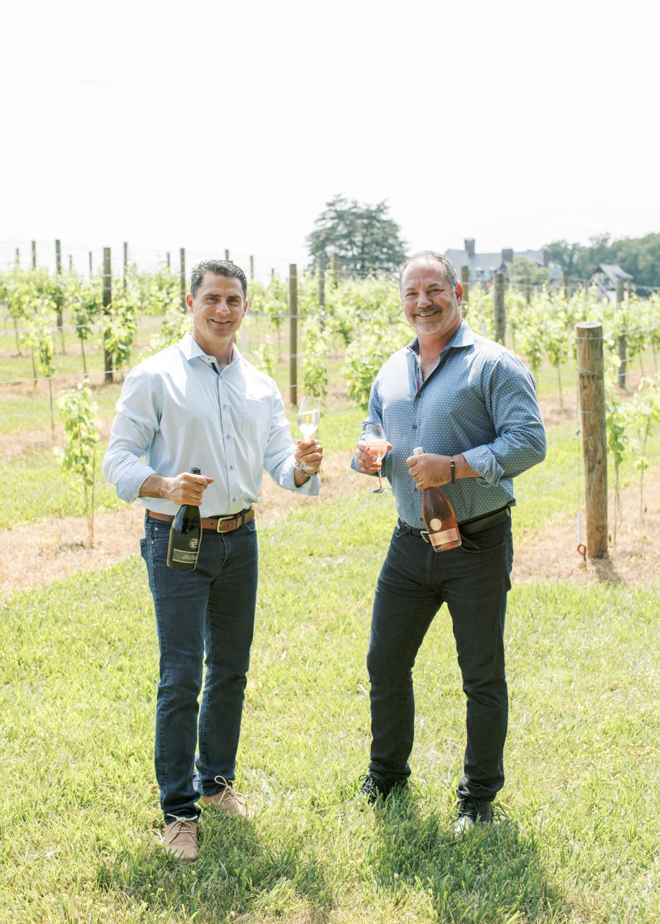 7LV founders Chad Hornik and Jeff Ottaviano standing together in the vineyard with wine.