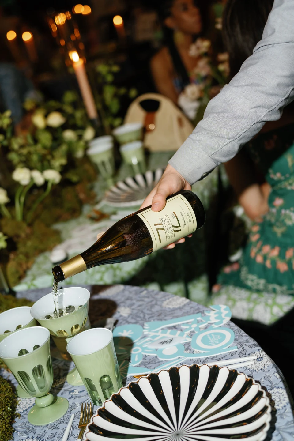 7 Lady Vineyards white wine poured at a table set with patterned plates and green glasses